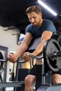 Hombre joven ejecutando ejercicio de extensión de piernas en máquina para fortalecer los cuádriceps en el gimnasio